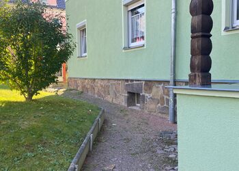 Fußweg an einem Haus vor der Sanierung